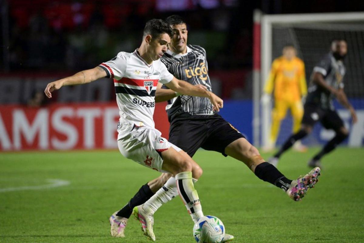 Sao Paulo's midfielder #08 Oscar (L) and Libertad's midfielder #06 Alvaro Campuzano fight for the ball during the Copa Libertadores group stage football match between Brazil's Sao Paulo and Paraguay's Libertad at the Morumbi stadium in Sao Paulo, Brazil, on May 14, 2025.  NELSON ALMEIDA / AFP