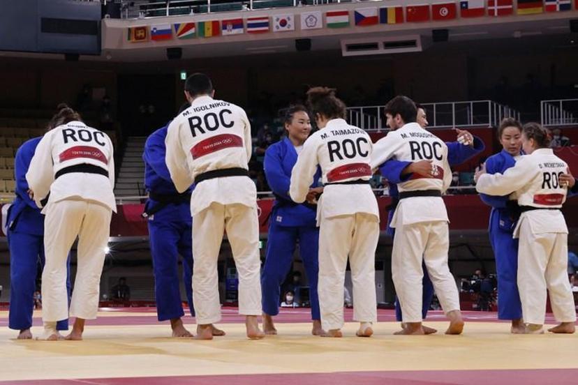 Team Russia (white) comforts team Mongolia at the end of their judo mixed team's quarterfinal match during the Tokyo 2020 Olympic Games at the Nippon Budokan in Tokyo on July 31, 2021.  Jack GUEZ / AFP