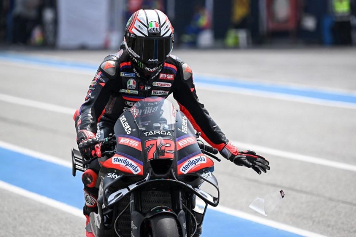 Aprilia Racing's Italian rider Marco Bezzecchi rips a strip off his visor during the free practice 1 session at the Buriram International Circuit in Buriram on February 27, 2026, ahead of the Thailand MotoGP Grand Prix.   Lillian SUWANRUMPHA / AFP