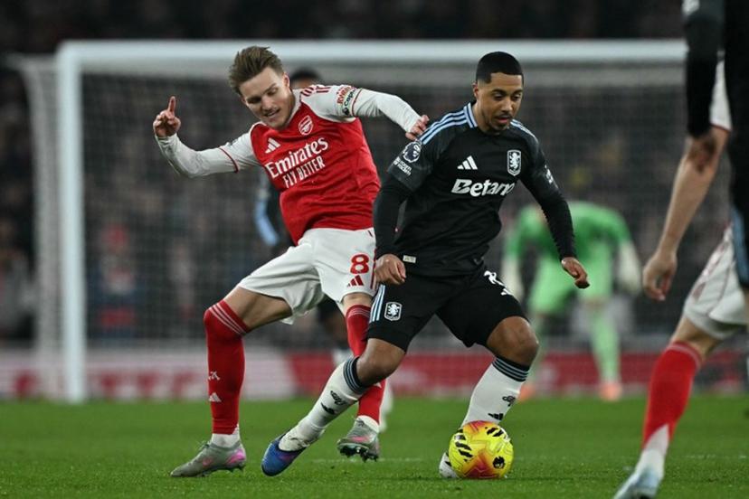 Arsenal's Norwegian midfielder #08 Martin Odegaard (L) fouls Aston Villa's Belgian midfielder  #08 Youri Tielemans (R) during the English Premier League football match between Arsenal and Aston Villa at the Emirates Stadium in London on December 30, 2025.   Ben STANSALL / AFP