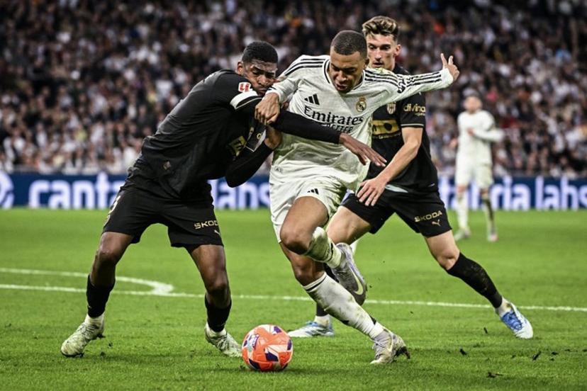 Real Madrid's French forward #09 Kylian Mbappe (C) vies for the ball with Valencia's Spanish defender #03 Cristhian Mosquera during the Spanish league football match between Real Madrid CF and Valencia CF at the Santiago Bernabeu stadium in Madrid on April 5, 2025.  JAVIER SORIANO / AFP