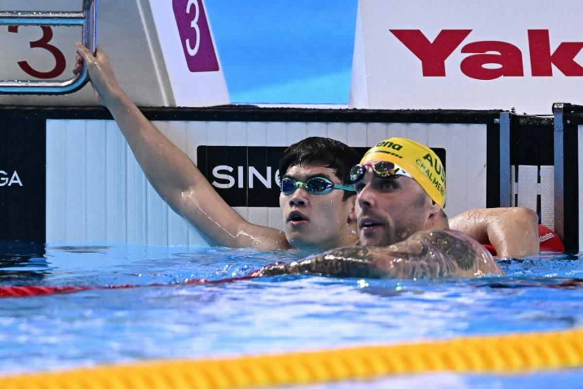 China's swimmer Pan Zhanle (L) and Australia's swimmer Kyle Chalmers react after a semi-final of the men's 100m freestyle swimming event during the 2025 World Aquatics Championships in Singapore on July 30, 2025.  MANAN VATSYAYANA / AFP