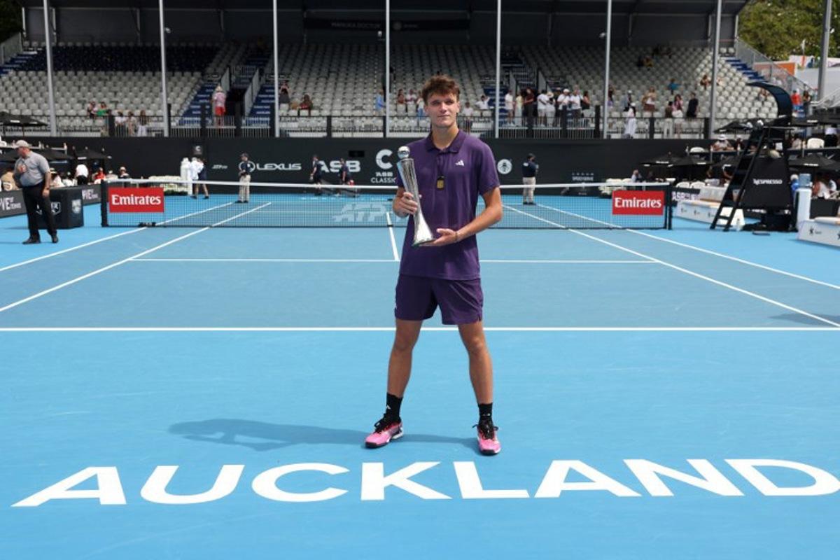 Czech Republic's Jakub Mensik poses with his trophy after victory against Argentina's Sebastian Baez in their men's singles final match at the ATP Auckland Classic tennis tournament in Auckland on January 17, 2026.  Michael Bradley / AFP