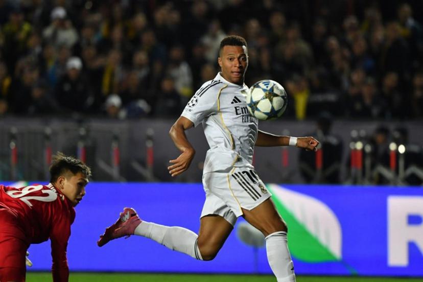 Real Madrid's French forward #10 Kylian Mbappe (R) scores his team's second goal past Kairat Almaty's Kazakh goalkeeper #82 Sherhan Kalmurza (L) during the UEFA Champions League first round day 2 football match between Kairat Almaty and Real Madrid at the Almaty Ortalyk stadion in Almaty on September 30, 2025.  Vyacheslav OSELEDKO / AFP