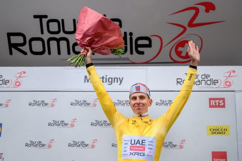 UAE Team Emirates-XRG's Slovenian rider Tadej Pogacar wearing the overall leader's yellow jersey celebrates on the podium of the first stage of the Tour of Romandie UCI cycling World tour, a 171.2 km loop from Martigny-Ville to Martigny-Ville, in Martigny, on April 29, 2026.  Fabrice COFFRINI / AFP