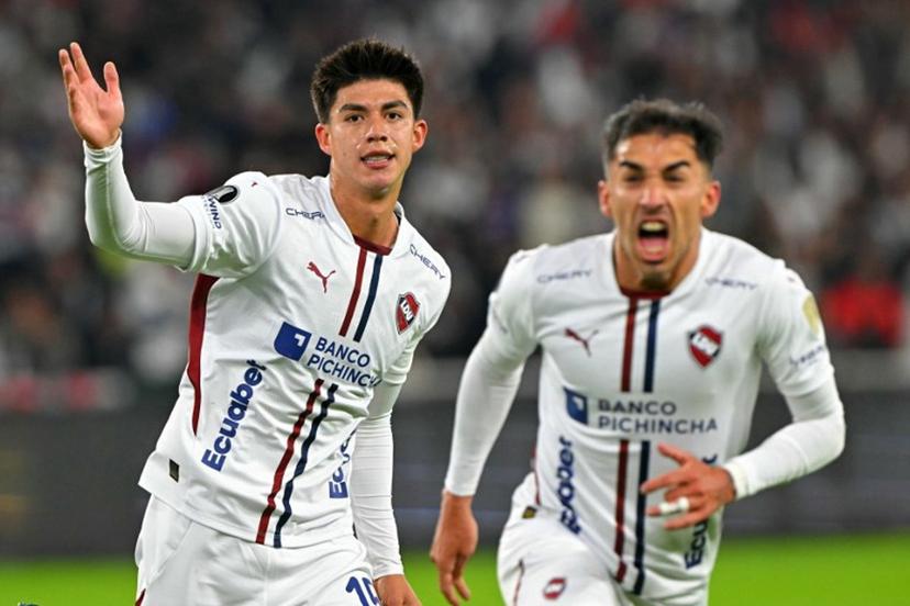 Liga de Quito's Bolivian midfielder #15 Gabriel Villamil (L) celebrates with a teammate scoring his team's first goal during the Copa Libertadores semifinal first leg football match between Ecuador's Liga de Quito and Brazil's Palmeiras at the Rodrigo Paz Delgado stadium in Quito on October 23, 2025.  Rodrigo BUENDIA / AFP