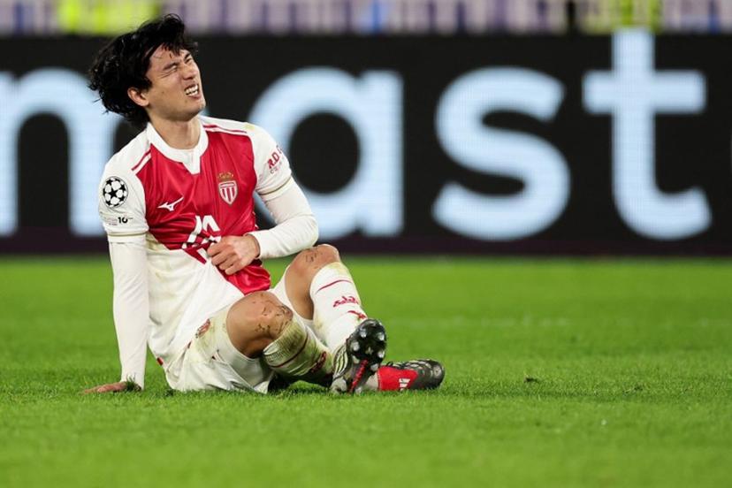 Monaco's Japanese forward #18 Takumi Minamino reacts after colliding with Galatasaray's Hungarian forward #07 Roland Sallai (unseen) during the UEFA Champions League, league phase, football match between Monaco and Galatasaray, at the Stade Louis II stadium, in Monaco, on December 9, 2025.  Valery HACHE / AFP