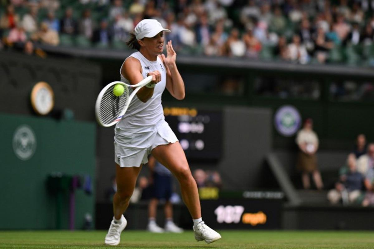 Poland's Iga Swiatek plays a forehand return to US player Danielle Collins during their women's singles third round tennis match on the sixth day of the 2025 Wimbledon Championships at The All England Lawn Tennis and Croquet Club in Wimbledon, southwest London, on July 5, 2025.  Glyn KIRK / AFP