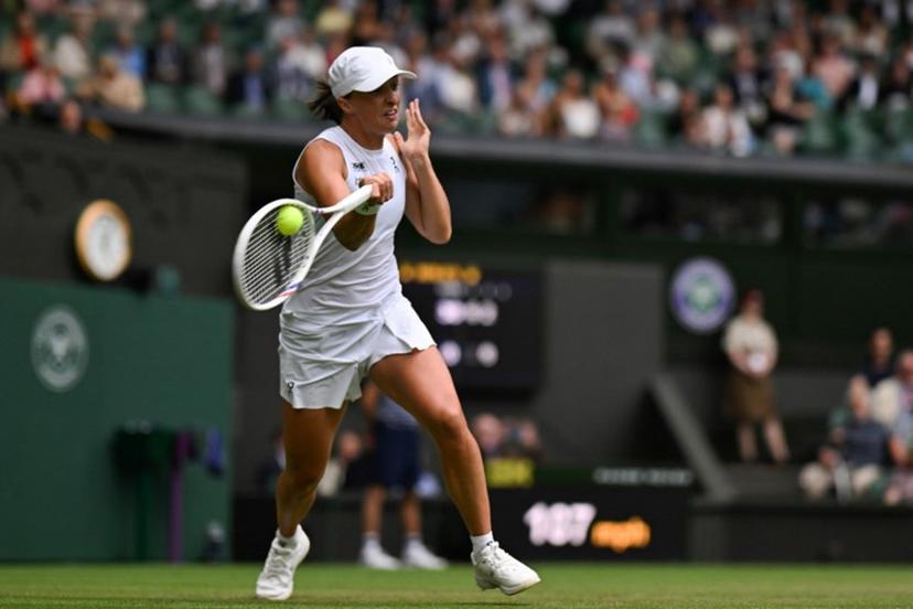 Poland's Iga Swiatek plays a forehand return to US player Danielle Collins during their women's singles third round tennis match on the sixth day of the 2025 Wimbledon Championships at The All England Lawn Tennis and Croquet Club in Wimbledon, southwest London, on July 5, 2025.  Glyn KIRK / AFP