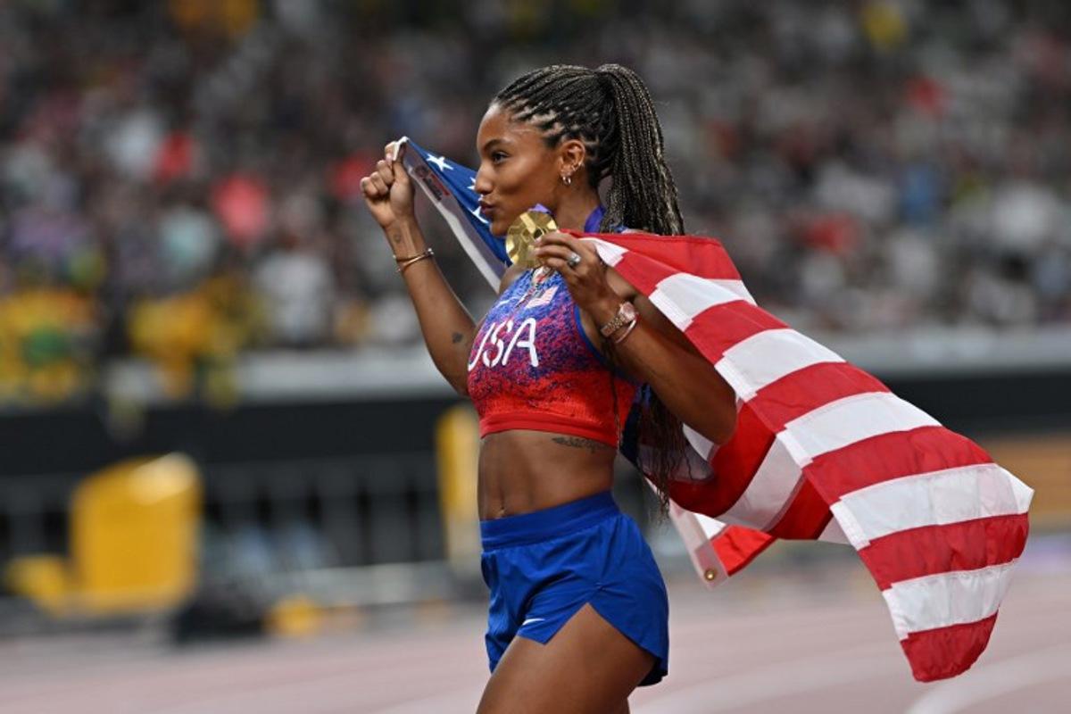 US' athlete Tara Davis-Woodhall celebrates with her gold medal after winning the women's long jump final during the World Athletics Championships in Tokyo on September 14, 2025.  Andrej ISAKOVIC / AFP