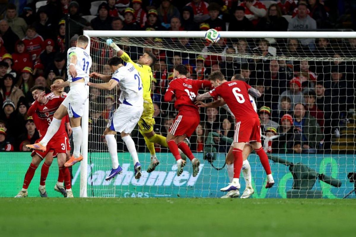 Bosnia-Herzegovina's forward Edin Dzeko scores the team's first goal during the FIFA World Cup qualification semi-final football match between Wales and Bosnia and Herzegovina, at Cardiff City Stadium, in Cardiff, on March 26, 2026.   Darren Staples / AFP