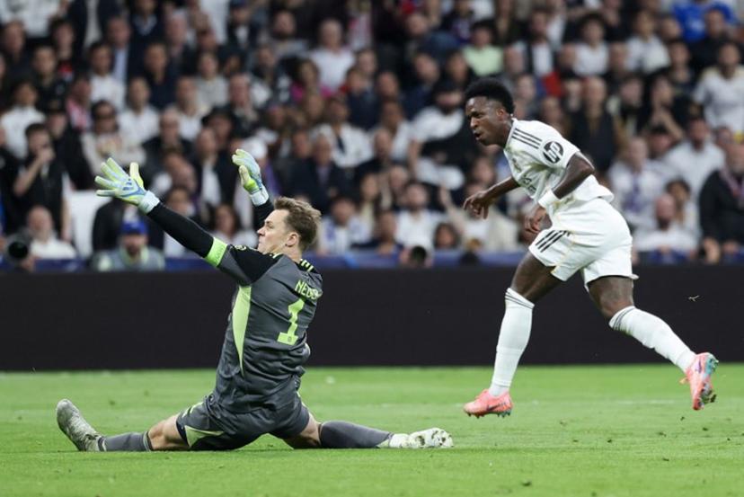 Real Madrid's Brazilian forward #07 Vinicius Junior (R) tries to score past Bayern Munich's German goalkeeper #01 Manuel Neuer during the UEFA Champions League quarter final first leg football match between Real Madrid CF and FC Bayern Munich at Santiago Bernabeu Stadium in Madrid on April 7, 2026.  Thomas COEX / AFP