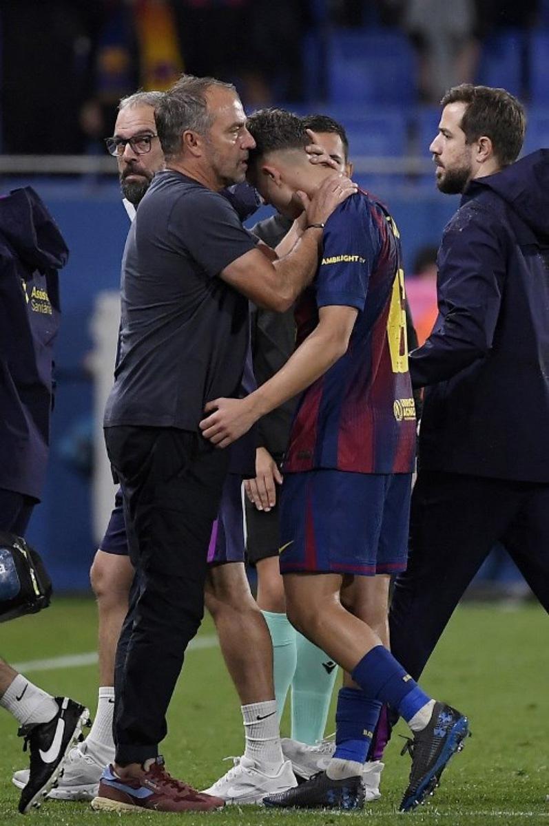 Barcelona's German coach Hans-Dieter Flick comforts Barcelona's Spanish midfielder #16 Fermin Lopez injured during the Spanish league football match between FC Barcelona and Getafe CF at Johan Cruyff Stadium in Barcelona on September 21, 2025.  Josep LAGO / AFP