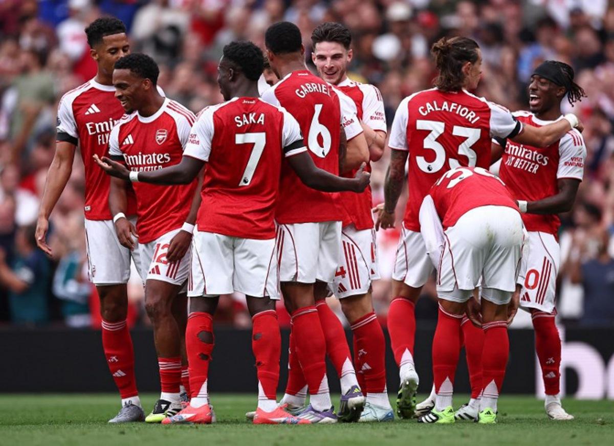 Arsenal's Dutch defender #12 Jurrien Timber (2L) is mobbed by teammates after scoring the opening goal during the English Premier League football match between Arsenal and Leeds United at the Emirates Stadium in London on August 23, 2025.   HENRY NICHOLLS / AFP