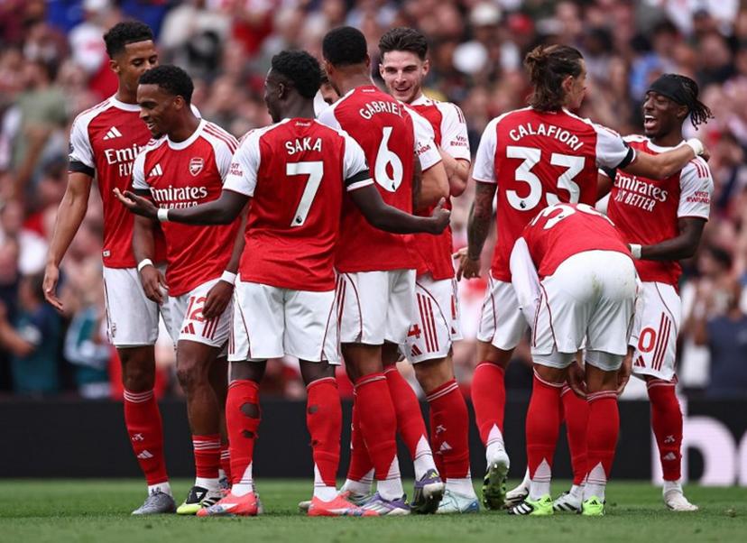 Arsenal's Dutch defender #12 Jurrien Timber (2L) is mobbed by teammates after scoring the opening goal during the English Premier League football match between Arsenal and Leeds United at the Emirates Stadium in London on August 23, 2025.   HENRY NICHOLLS / AFP