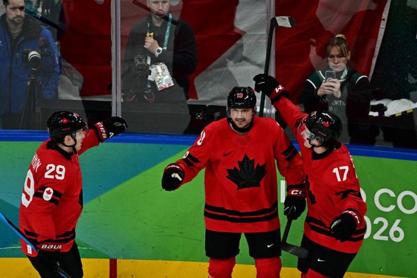 Canada's #13 Sam Reinhart (C) celebrates with teammates after scoring his team's first goal during the men's play-off semi-final ice hockey match between Canada and Finland at the Milano Santagiulia Ice Hockey Arena during the Milano Cortina 2026 Winter Olympic Games in Milan, on February 20, 2026.  JULIEN DE ROSA / AFP