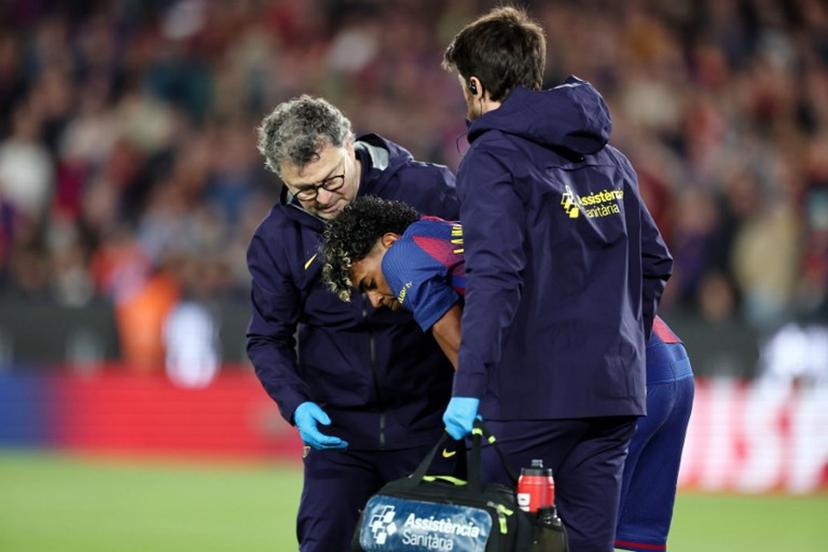 Barcelona's Spanish forward #10 Lamine Yamal receives medical attention after sustaining an injury during the Spanish league football match between FC Barcelona and RC Celta de Vigo at Camp Nou stadium in Barcelona on April 22 , 2026.  Josep LAGO / AFP