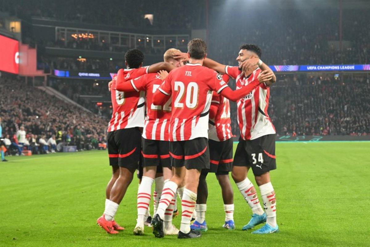 PSV's players celebrate after scoring their first goal during the UEFA Champions League 1st round day 2 football match between PSV Eindhoven (NED) and Sporting Lisbon (POR) at the The Philips Stadion, in Eindhoven, on October 1, 2024.  NICOLAS TUCAT / AFP