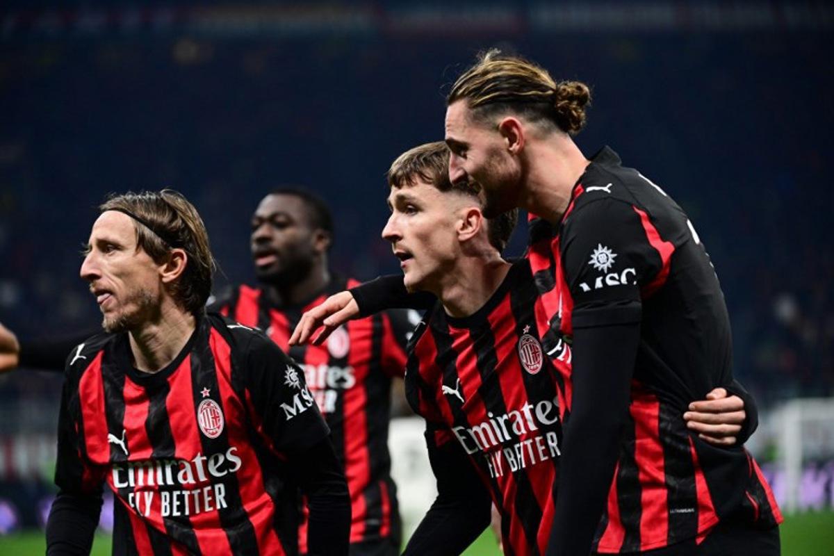 AC Milan's Croatian midfielder #14 Luka Modric (L), AC Milan's Begian midfielder #56 Alexis Saelemaekers (2ndR) and AC Milan's French midfielder  #12 Adrien Rabiot (R) celebrate their team's first goal during the Italian Serie A football match between AC Milan and Lazio at the San Siro stadium in Milan on November 29, 2025.  Piero CRUCIATTI / AFP