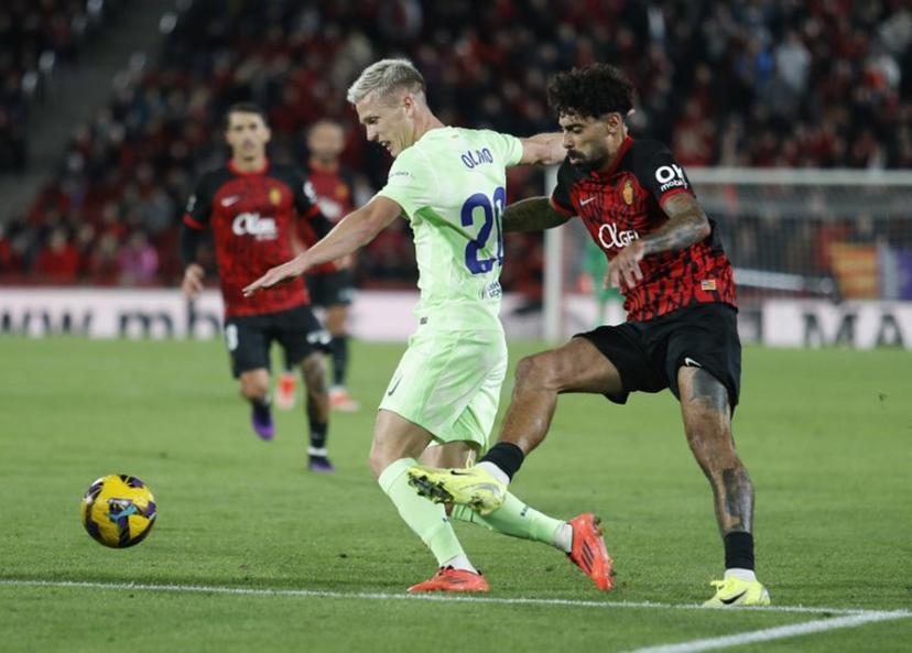 Barcelona's Spanish midfielder #20 Dani Olmo (L) vies with Real Mallorca's Portuguese midfielder #12 Samu Costa during the Spanish league football match between RCD Mallorca and FC Barcelona at the Mallorca Son Moix stadium in Palma de Mallorca on December 3, 2024.  JAIME REINA / AFP