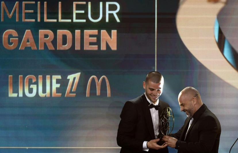 LOSC Lille's French goalkeeper Lucas Chevalier reacts as he receives the French Ligue 1 football's Best Goalkeeper of the Season award presented by French goalkeeper Jeremy Janot, during the televised UNFP (French National Professional Football players Union) trophy ceremony, in Paris on May 11, 2025.  FRANCK FIFE / AFP