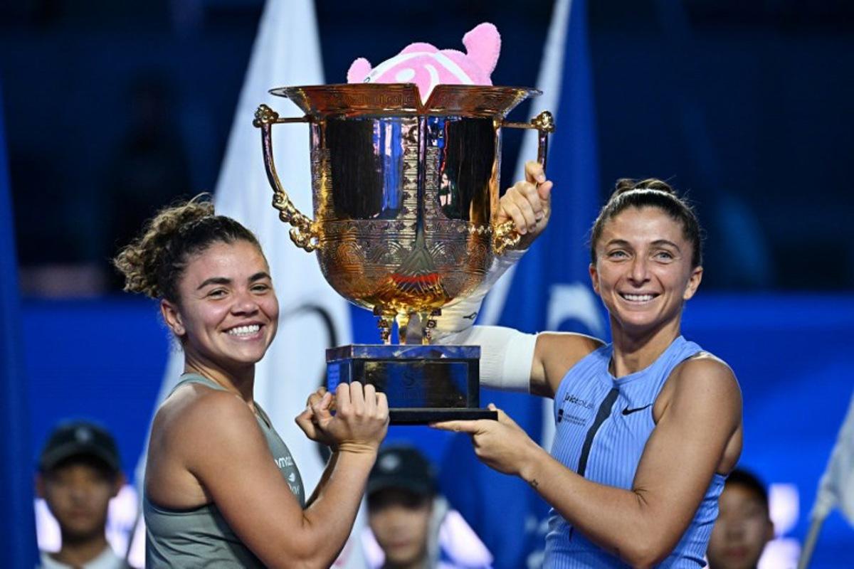 Italy's Sara Errani (R) and Jasmine Paolini celebrate with their trophy after winning their women's doubles final against Japan's Miyu Kato and Hungary's Fanny Stollar at the China Open tennis tournament in Beijing on October 5, 2025.  Pedro Pardo / AFP