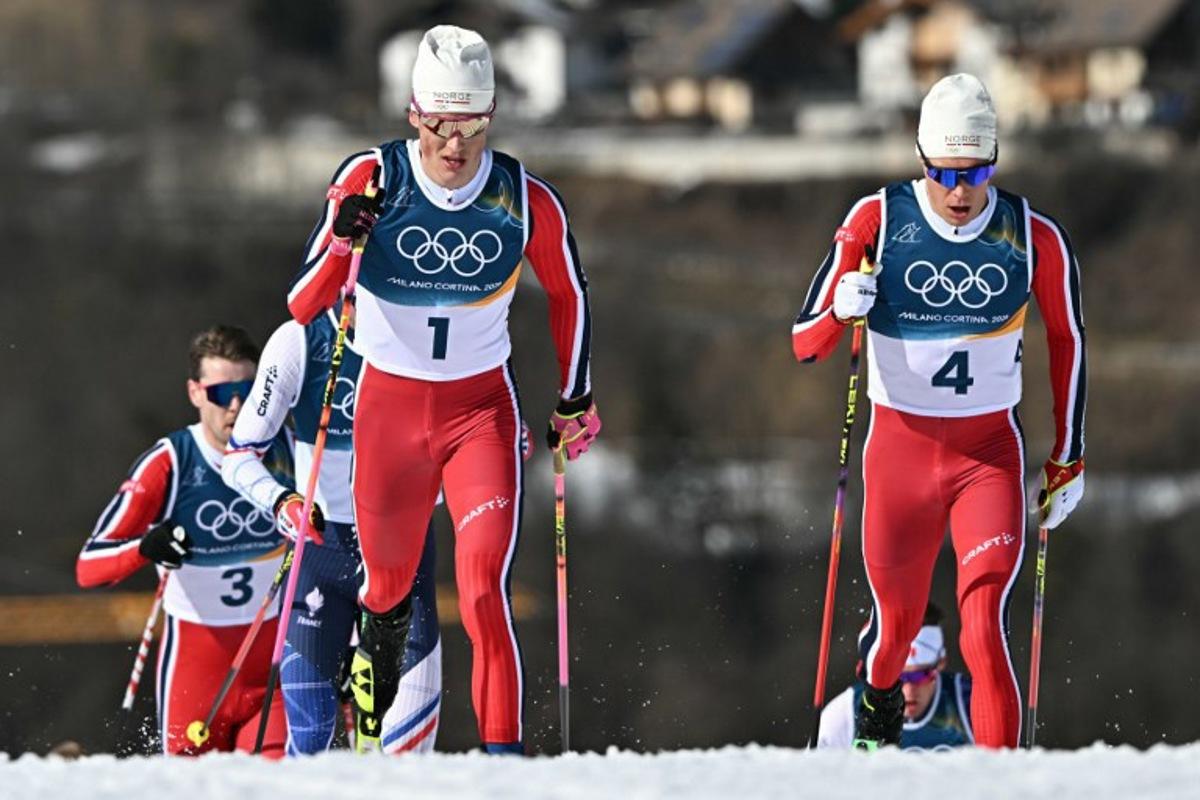 Norway's Johannes Hoesflot Klaebo (L) and Norway's Martin Loewstroem Nyenget compete during the men's cross country 10km + 10km skiathlon event of the Milano Cortina 2026 Winter Olympic Games at Tesero Cross-Country Skiing Stadium in Lago di Tesero (Val di Fiemme), on February 8, 2026.  Javier SORIANO / AFP