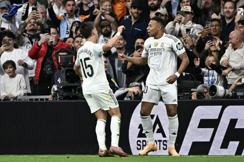 Real Madrid's French forward #10 Kylian Mbappe celebrates with Real Madrid's Turkish midfielder #15 Arda Guler (L) after scoring their first goal during the Spanish league football match between Real Madrid CF and FC Barcelona at the Santiago Bernabeu stadium in Madrid on October 26 , 2025.  JAVIER SORIANO / AFP