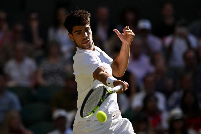Spain's Carlos Alcaraz plays a forehand return to Britain's Cameron Norrie during their men's singles quarter-final tennis match on the ninth day of the 2025 Wimbledon Championships at The All England Lawn Tennis and Croquet Club in Wimbledon, southwest London, on July 8, 2025.  Glyn KIRK / AFP