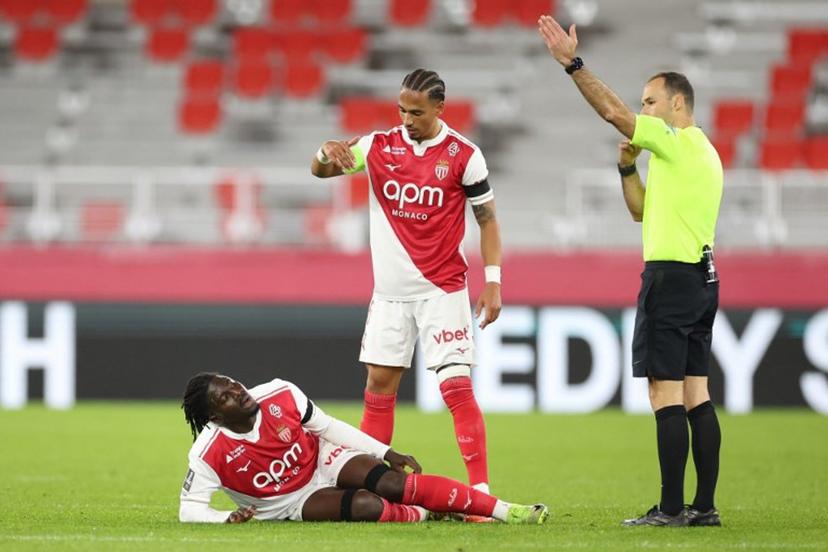 Monaco's Ghanaian defender #22 Mohammed Salisu (L) sustains an injury during the French L1 football match between AS Monaco and Olympique Lyonnais (OL) at the Stade Louis II in the Principality of Monaco on January 3, 2026.  Valery HACHE / AFP