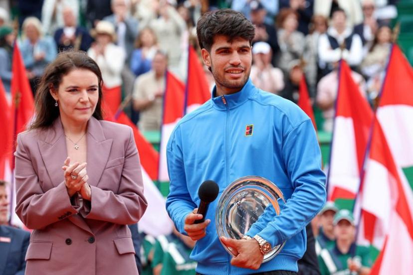 Second placed Spain's Carlos Alcaraz (R) delivers a speech flanked by President of the Monegasque Federation, the Rolex Masters 1000 and the Monte-Carlo Country Club Melanie de Massy during the podium ceremony and following the Monte Carlo ATP Masters Series Tournament final tennis match on Court Rainier III at the Monte-Carlo Country Club in Roquebrune-Cap-Martin, south-eastern France on April 12, 2026. Valery HACHE / AFP