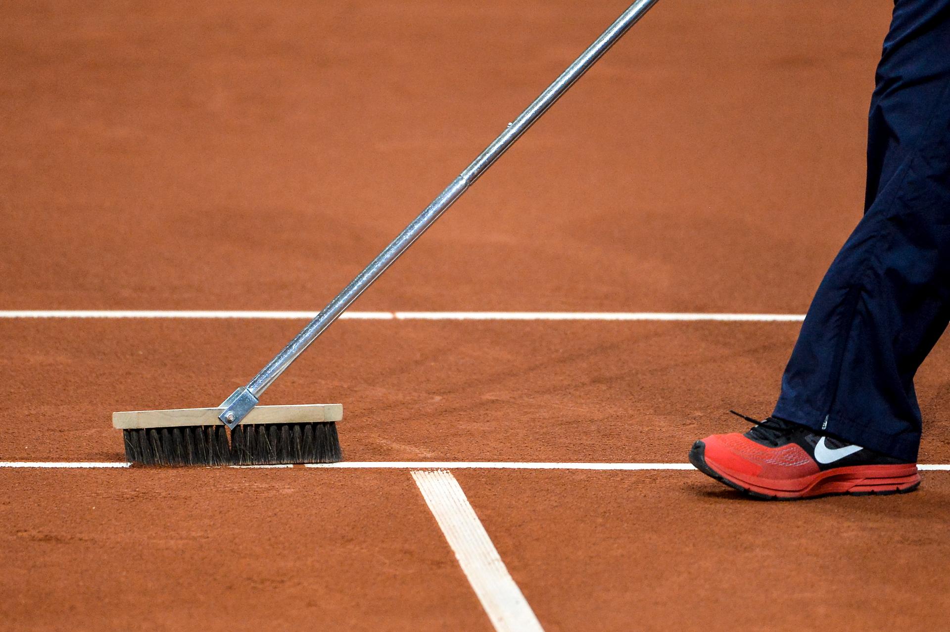 20151124 - GENT, BELGIUM: Illustration shows someone cleaning the line on the clay tennis court at a training practice ahead of the Davis Cup World Group final between Belgium and Great Britain, Tuesday 24 November 2015, at Flanders Expo in Gent. The final will be played from 27 to 29 November 2015 in Gent Flanders Expo. BELGA PHOTO DIRK WAEM