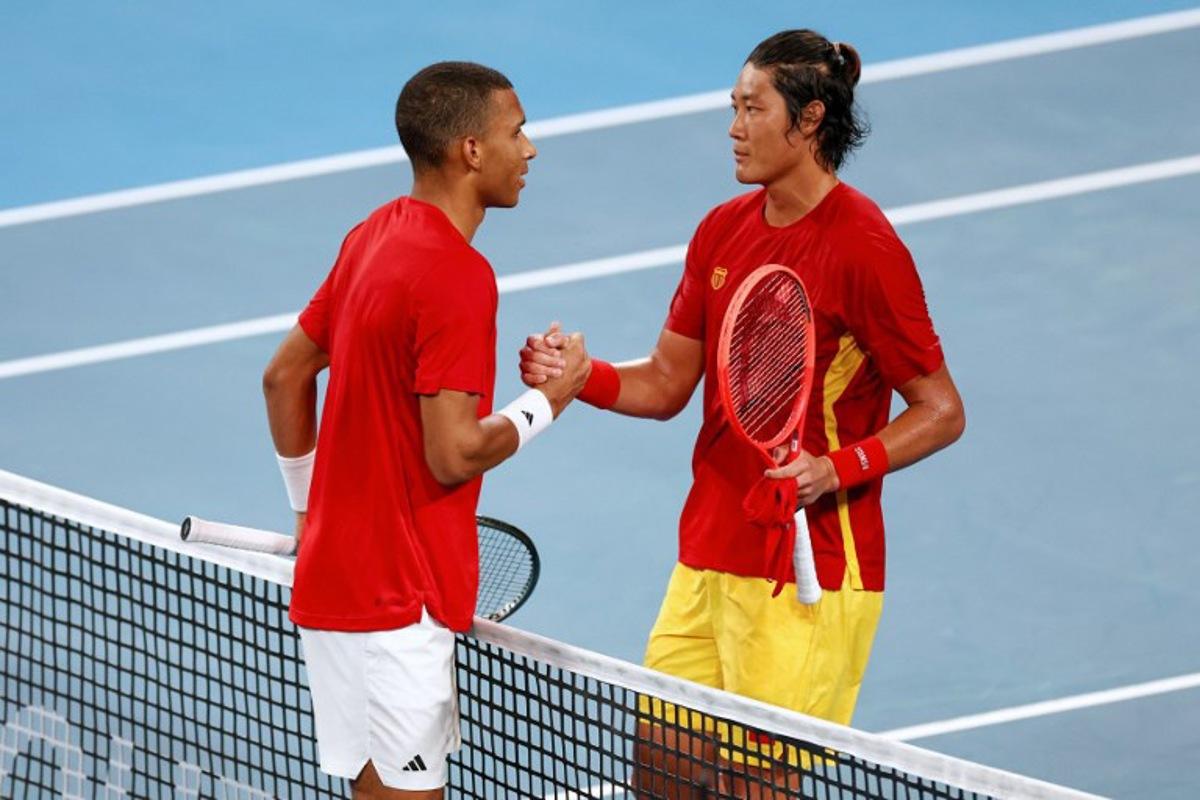 Canada's Felix Auger-Aliassime (L) is congratulated by China's Zhang Zhizhen after his victory in the men's singles match at the United Cup tennis tournament on Ken Rosewood Arena in Sydney on January 4, 2026.  Izhar KHAN / AFP