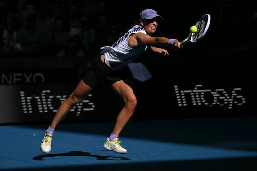 Poland's Iga Swiatek hits a return to Czech Republic's Marie Bouzkova during their women's singles match on day five of the Australian Open tennis tournament in Melbourne on January 22, 2026.  WILLIAM WEST / AFP