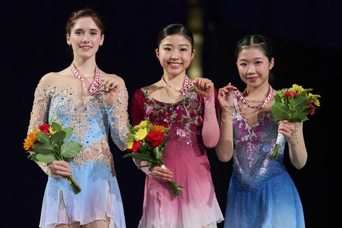 Gold medalist Mone Chiba of Japan (C) poses with silver medalist Isabeau Levito of the United States (L) and Ami Nakai of Japan during the victory ceremony for the women's competition during the ISU Grand Prix of Figure Skating 2025 Skate Canada International at the SaskTel Centre in Saskatoon, Saskatchewan, Canada on November 1, 2025.  Geoff Robins / AFP