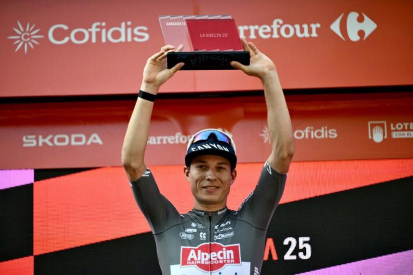 Stage winner Team Alpecin's Belgian rider Jasper Philipsen celebrates on the podium of the first stage of the Vuelta a Espana, a 183 km race between Torino - Reggia di Venaria and Novara, in Italy's Piemonte region, on August 23, 2025.    Marco BERTORELLO / AFP