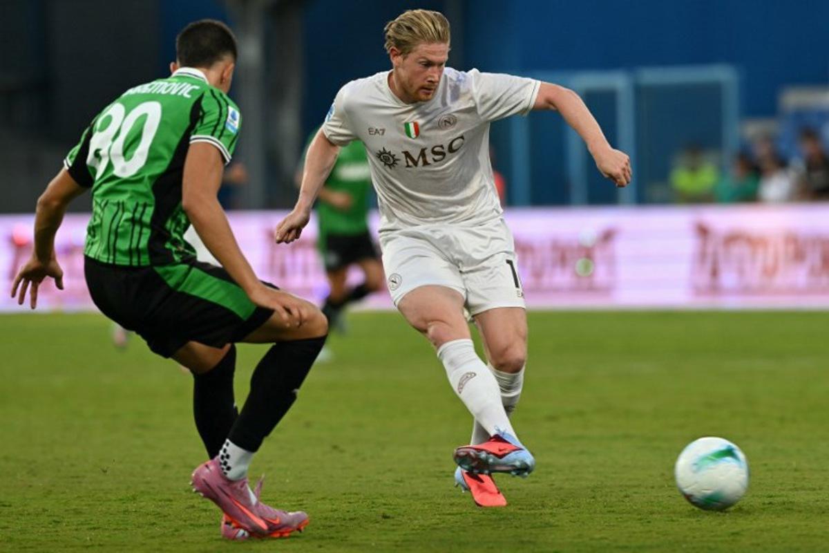 Napoli's Belgian midfielder #11 Kevin De Bruyne fights for the ball with Sassuolo's Bosnian defender #80 Tarik Muharemovic during the Italian Serie A football match between Sassuolo and Napoli at the Mapei - Città del Tricolore stadium in Reggio Emilia, on August 23, 2025.  Stefano RELLANDINI / AFP