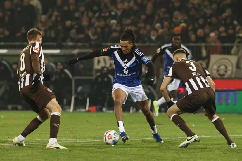Hamburg's US forward #19 Damion Downs vies for the ball with St Pauli's Swedish defender #08 Eric Smith and St Pauli's Estonian defender #03 Karol Mets during the German first division Bundesliga football derby match between FC St Pauli and Hamburg HSV in Hamburg, northern Germany on January 23, 2026.  IBRAHIM OT / AFP