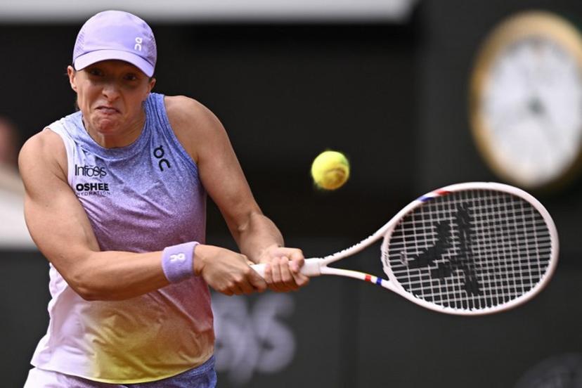 Poland's Iga Swiatek plays a backhand return to Britain's Emma Raducanu during their women's singles match on day 4 of the French Open tennis tournament on Court Philippe-Chatrier at the Roland-Garros Complex in Paris on May 28, 2025.  JULIEN DE ROSA / AFP