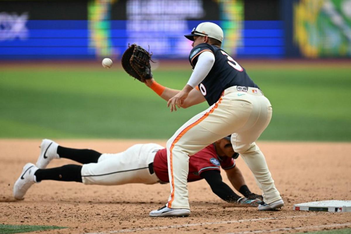 Arizona Diamondbacks' #11 Jose Fernandez dives back to first base past San Diego Padres' #30 Gavin Sheets during the MLB World Tour Mexico City Series game between the Arizona Diamondbacks and the San Diego Padres at Alfredo Harp Helu Stadium in Mexico City on April 26, 2026.  YURI CORTEZ / AFP