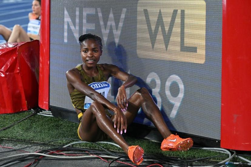 Bahrain's Winfred Mutile Yavi rests next to a board displaying her world leading (WL) performance in this season after winning the women's 3000m steeplechase event of the Diamond League athletics meeting at the Olympic stadium in Rome on August 30, 2024.  Tiziana FABI / AFP