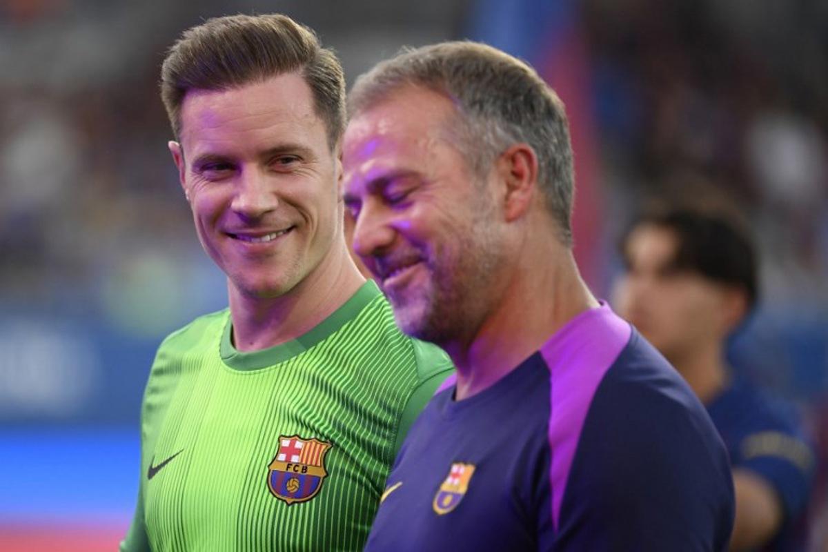 Barcelona's German coach Hans-Dieter Flick (R) and Barcelona's German goalkeeper Marc-Andre Ter Stegen speak before the 60th Joan Gamper Trophy football match between FC Barcelona and Como 1907 at Johan Cruyff Stadium in Barcelona on August 10, 2025. Josep LAGO / AFP