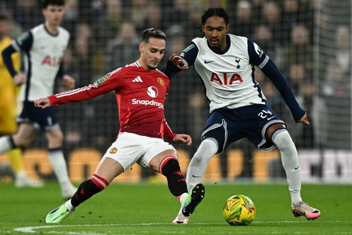 Manchester United's Brazilian midfielder #21 Antony (L) vies with Tottenham Hotspur's English defender #24 Djed Spence during the English League Cup quarter-final football match between Tottenham Hotspur and Manchester United at the Tottenham Hotspur Stadium in London, on December 19, 2024. Ben STANSALL / AFP