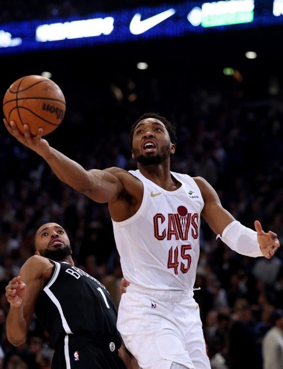 Cleveland Cavaliers' US Point Guard Donovan Mitchell (R) jumps to score in front of Brooklyn Nets' US Point Guard Mikal Bridges (L) during the NBA regular season basketball match between the Cleveland Cavaliers and the Brooklyn Nets at the Accor Arena in Paris on January 11, 2024. Emmanuel Dunand / AFP