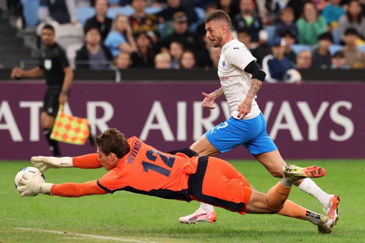 Sydney FC's goalkeeper Harrison Devenish-Meares dives to save a shot from Lion City Sailors' Maxime Lestienne during the second leg of the AFC Champions League Two semi-final at Allianz Stadium in Sydney on April 16, 2025. DAVID GRAY / AFP