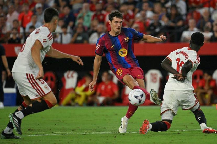 Barcelona's Danish defender #15 Andreas Christensen kicks the ball past Sevilla's Senegalese defender #12 Arouna Sangante during the Spanish league football match between Sevilla FC and FC Barcelona at the Ramon Sanchez Pizjuan stadium in Seville on September 19, 2026. JORGE GUERRERO / AFP