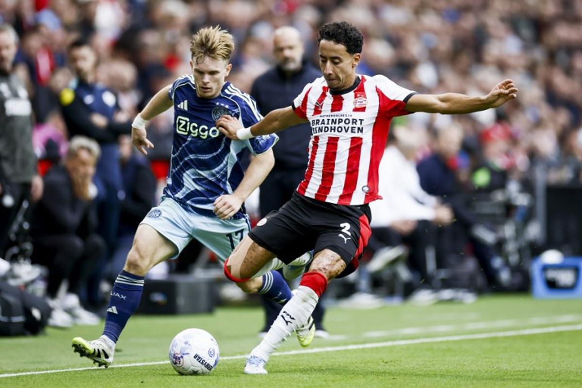 Ajax's Norwegian forward #17 Oliver Edvardsen and PSV Eindhoven Netherland's defender #02 Anass Salah-Eddine of fight for the ball during the Dutch Eredivisie football match between PSV Eindhoven and Ajax at the Phillips Stadium, in Eindhoven, on September 21, 2025. Koen van Weel / ANP / AFP