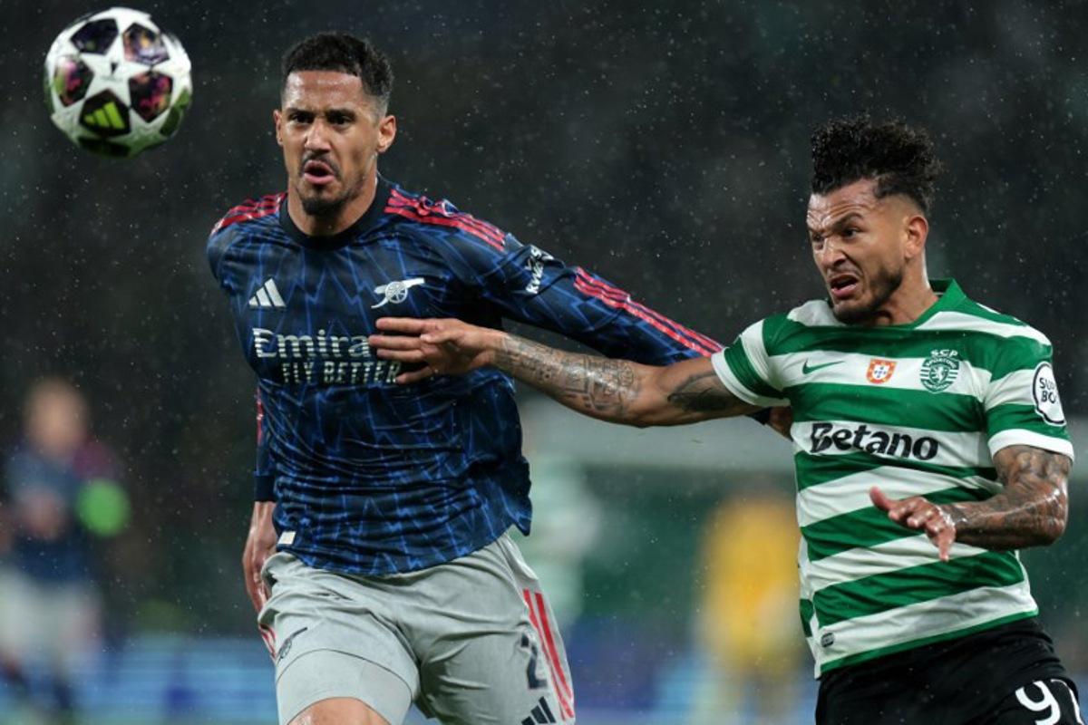 Arsenal's French defender #02 William Saliba (L) and Sporting Lisbon's Colombian forward #97 Luis Suarez fight for the ball during the UEFA Champions League quarter final first leg football match between Sporting CP and Arsenal at Jose Alvalade stadium in Lisbon on April 7, 2026. PATRICIA DE MELO MOREIRA / AFP