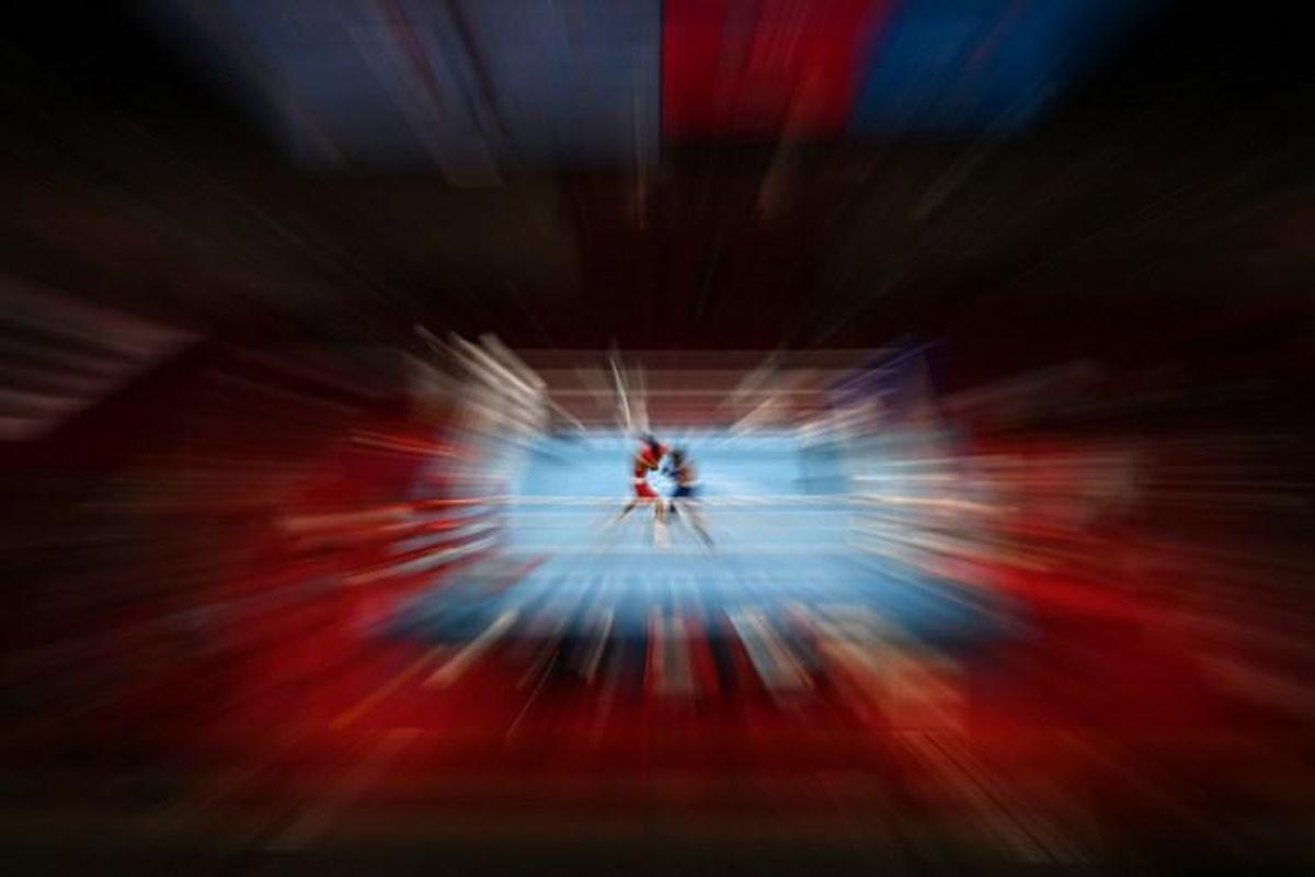 Kazakhstan's Saken Bibossinov (red) and Puerto Rico's Yankiel Rivera Figueroa fight during their men's fly (48-52kg) preliminaries boxing match during the Tokyo 2020 Olympic Games at the Kokugikan Arena in Tokyo on July 26, 2021. Luis ROBAYO / AFP