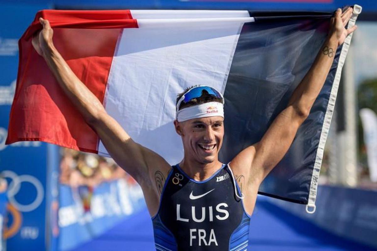 France's triathlete Vincent Luis waves a French national flag after crossing the finish line during the ITU World Triathlon Grand Final on August 31, 2019 in Lausanne. France's Vincent Luis won his first World Triathlon Championship title at the age of 30 in Lausanne, one year before the Olympic Games, a first for a Frenchman since Olivier Marceau in 2000. FABRICE COFFRINI / AFP